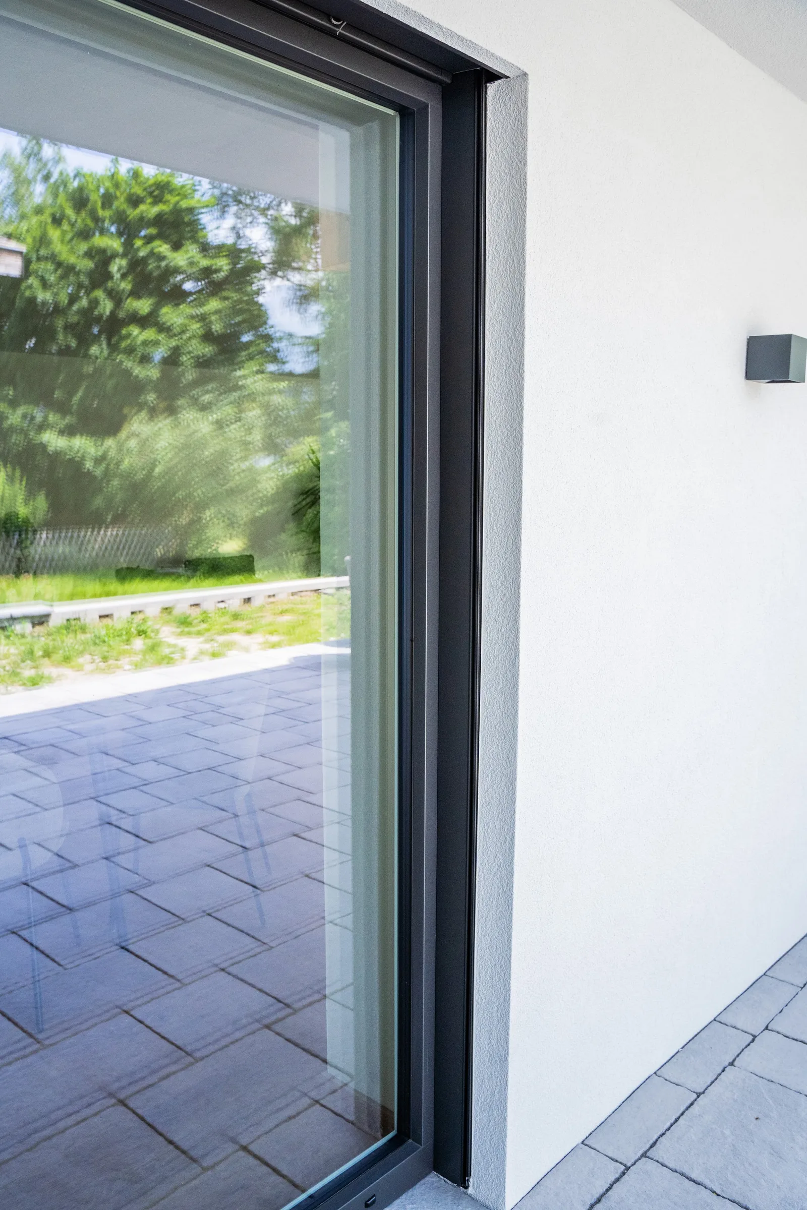 Schmale dunkle Verglasung an einer weißen Hauswand