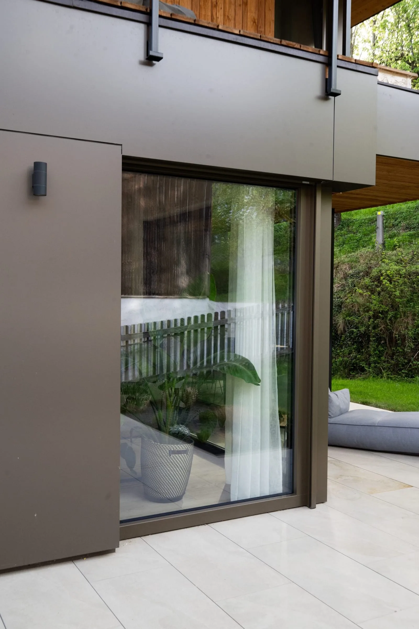 Dunkle Hebeschiebetür von außen mit Terrasse
