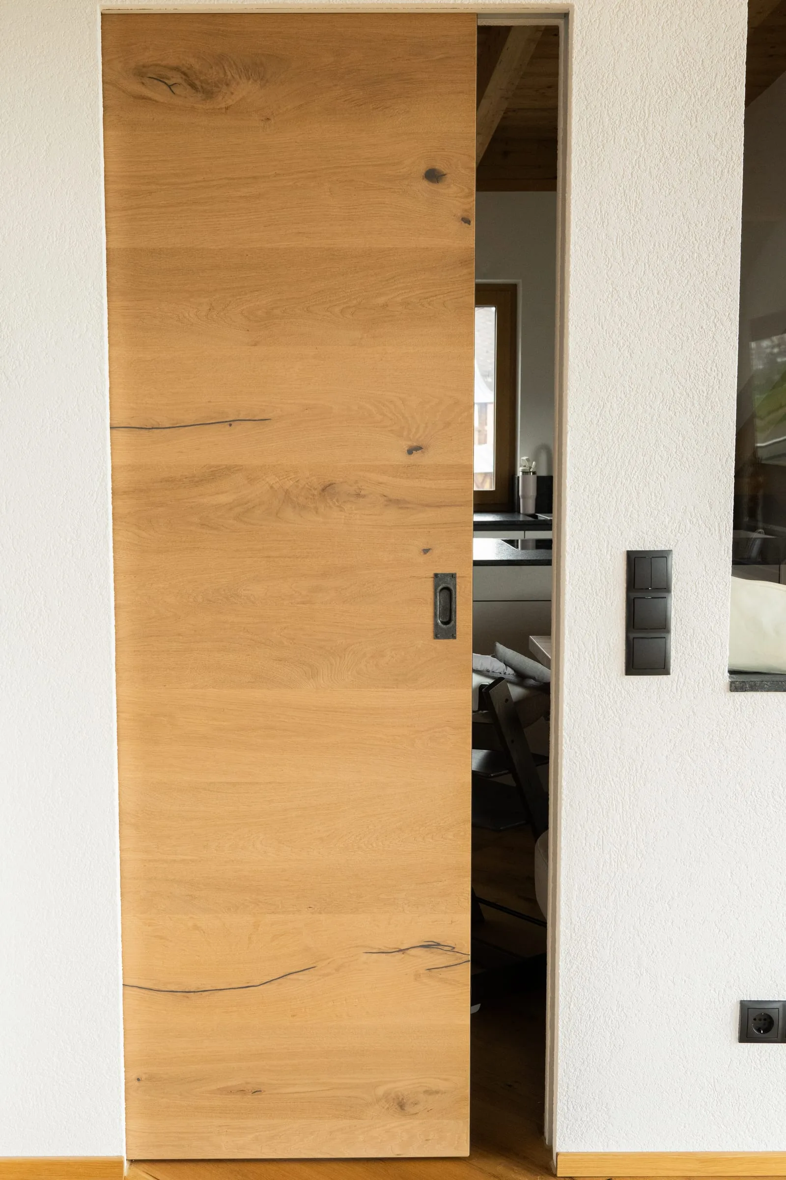 Innentür aus Eiche als Schiebetür vor einer weißen Wand